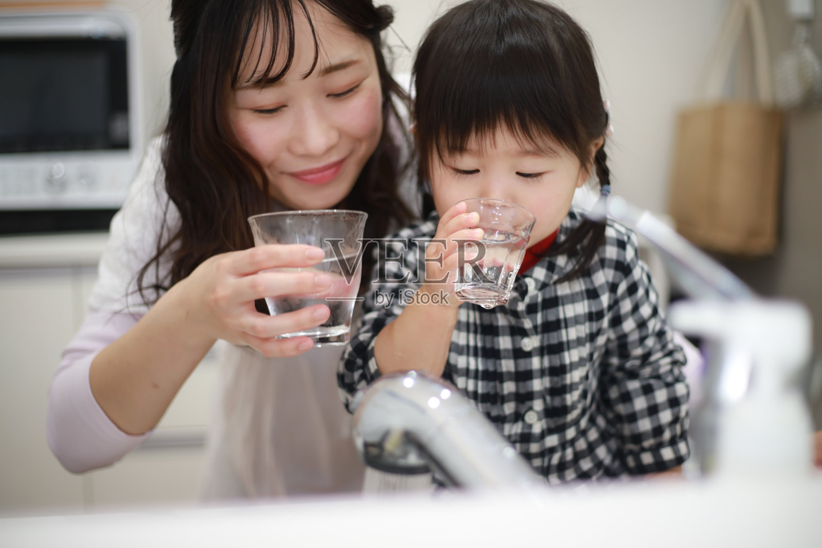 父母和孩子饮用自来水照片摄影图片