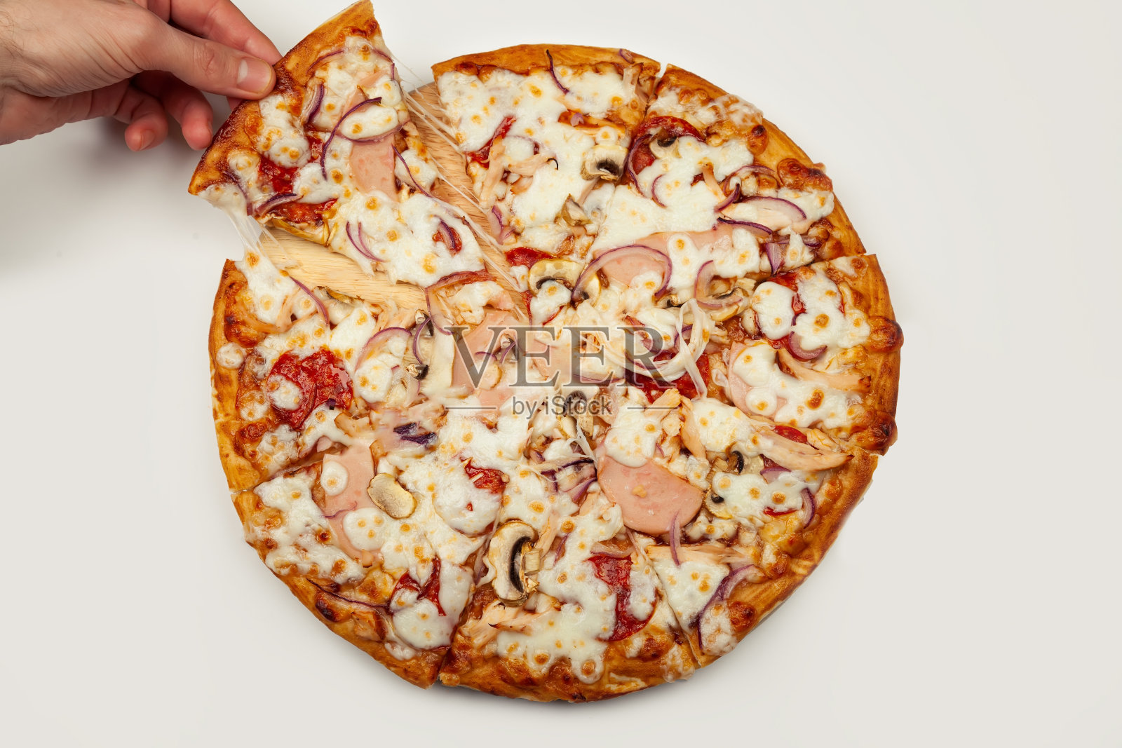 一个男人的手拿起一片美味的玛格丽塔披萨或玛格丽塔马苏里拉芝士披萨。一个男人拿起一片意大利披萨,拿出一块诱人的融化的奶酪照片摄影图片