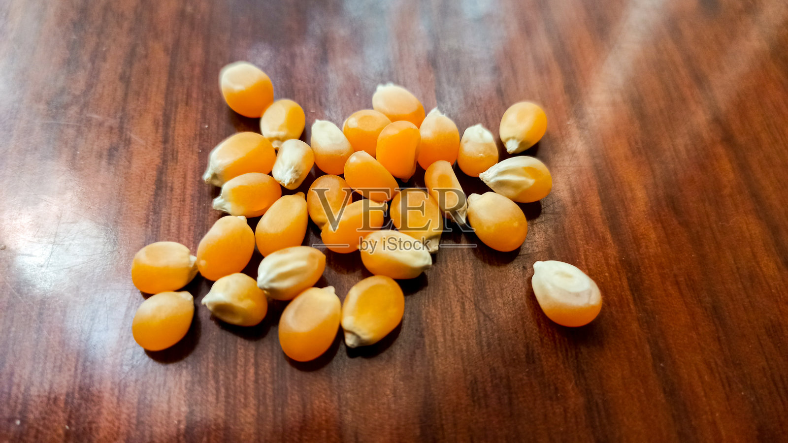 爆米花种子在木制的背景。照片摄影图片