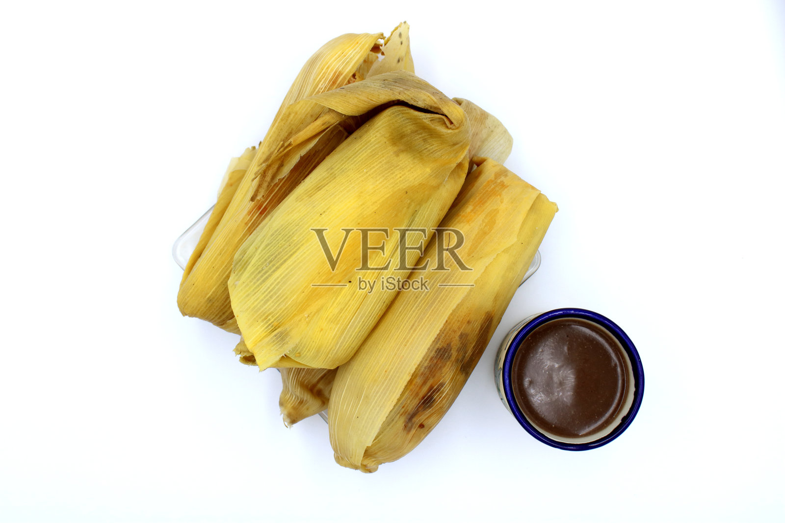 玉米粉蒸肉是一种源自拉丁美洲的食物,通常由玉米或米面团制成,馅料有肉、蔬菜、辣椒、水果和酱汁。它们用玉米叶或香蕉叶包裹。照片摄影图片