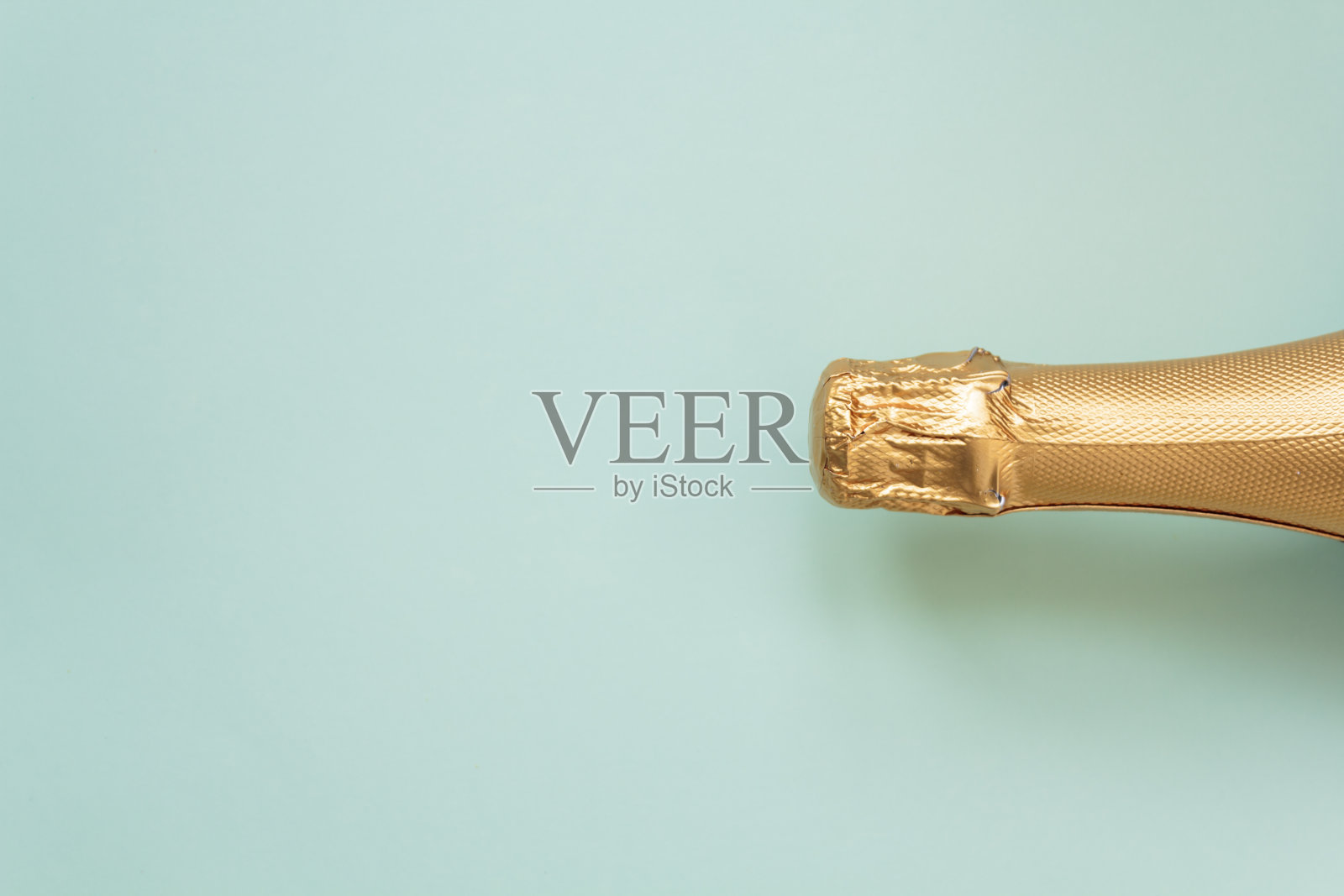 蓝色背景上的金色香槟派对瓶。俯视图,平躺与复制空间照片摄影图片