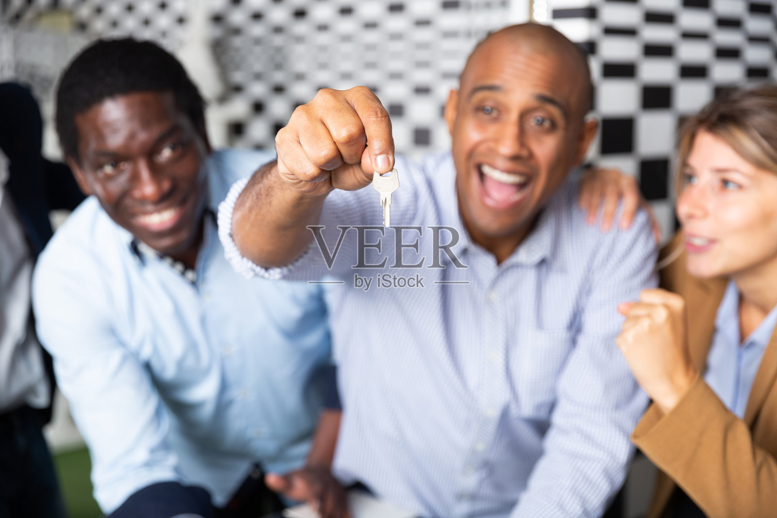 快乐的拉丁人和他的朋友在探索室的棋盘附近找到钥匙照片摄影图片