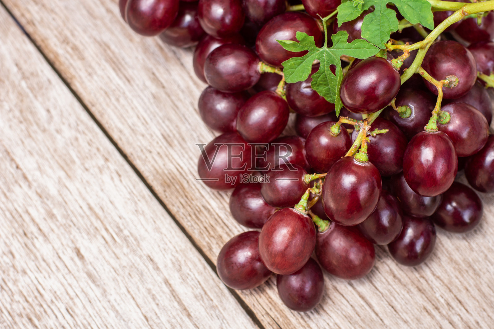 红色的葡萄果实带有绿色的叶子照片摄影图片