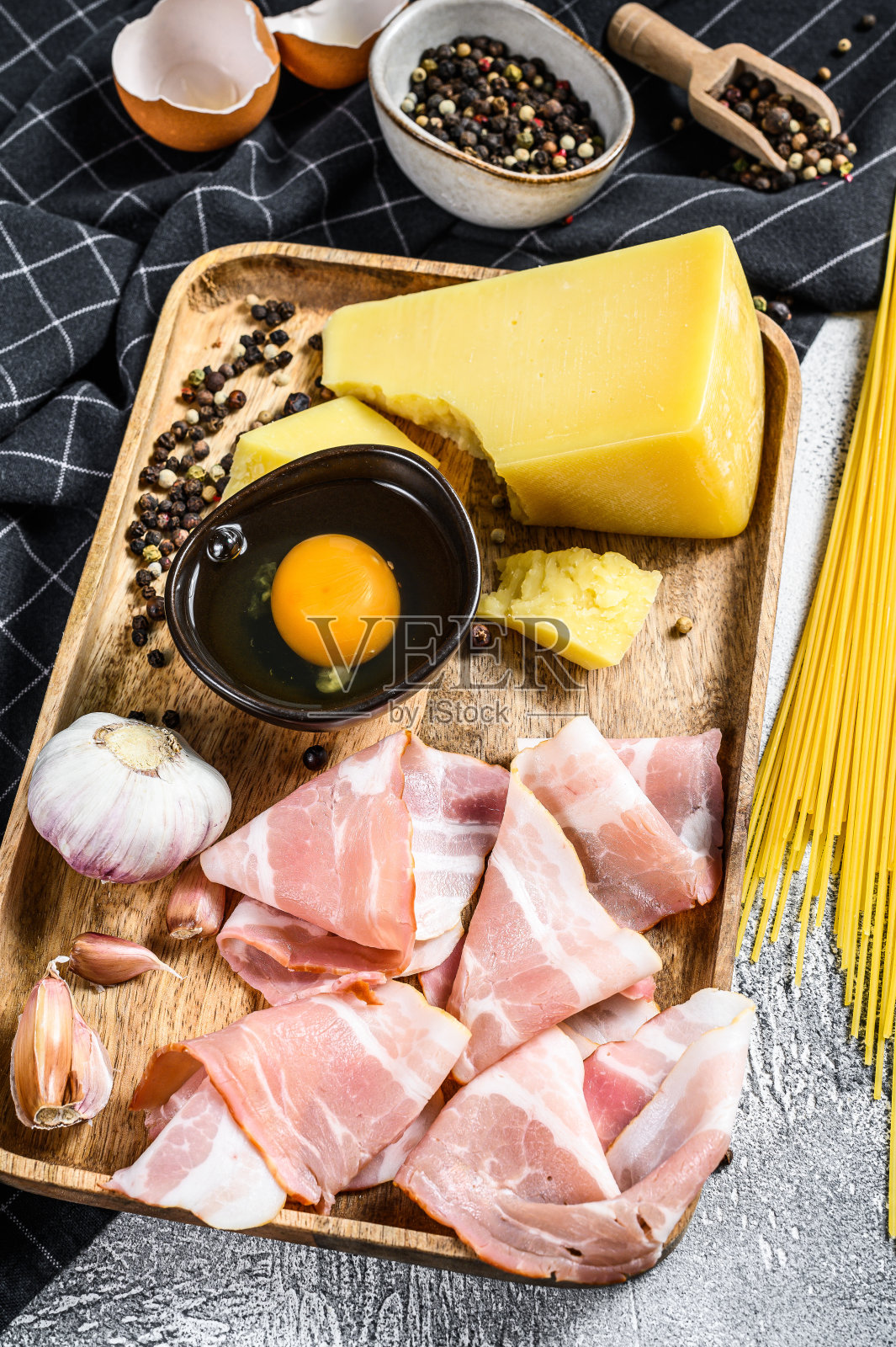 传统意大利通心粉的原料。培根,意大利面,帕尔马干酪和佩科里诺干酪,鸡蛋,大蒜。灰色的背景。俯视图照片摄影图片