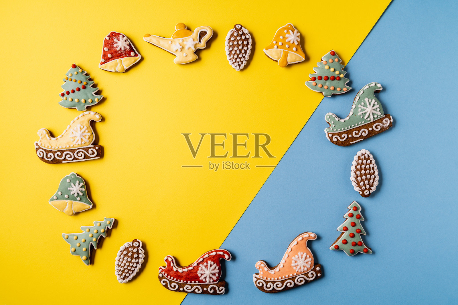 黄色和蓝色背景的圣诞姜饼。雪花,云杉,星形,雪橇,圆锥形,圆锥形,星形,钟形。照片摄影图片