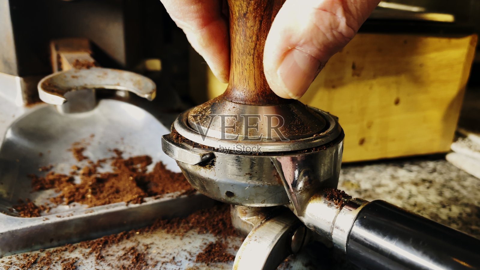 咖啡师捣碎研磨的咖啡来制作浓缩咖啡照片摄影图片