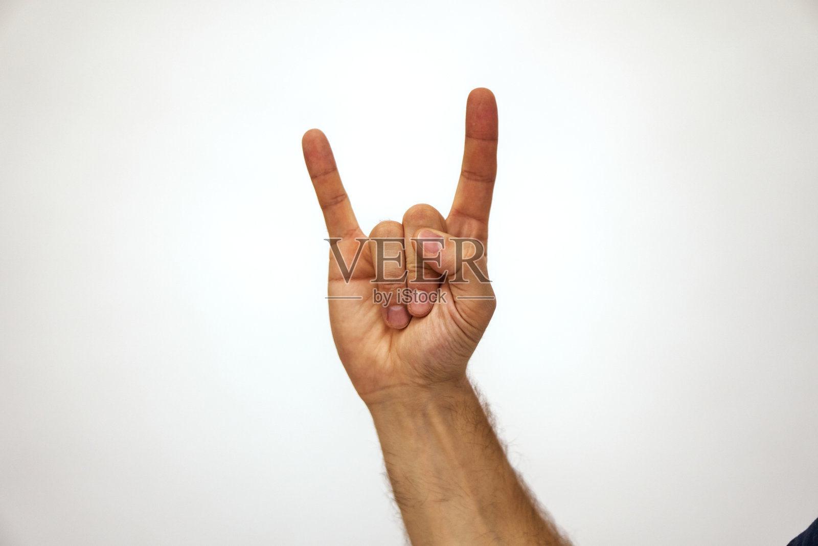 手放在白色上,表现出摇滚的姿态。一名白人男子举起了手照片摄影图片
