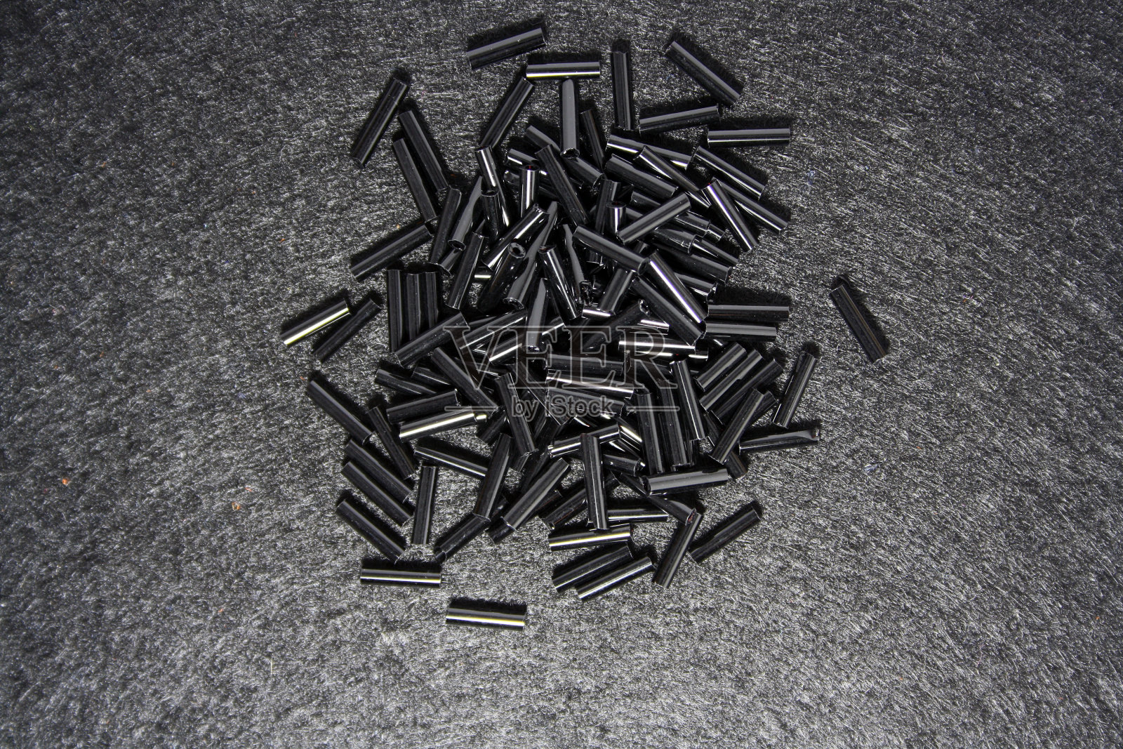 黑色毛毡背景上的黑色珠子。照片摄影图片