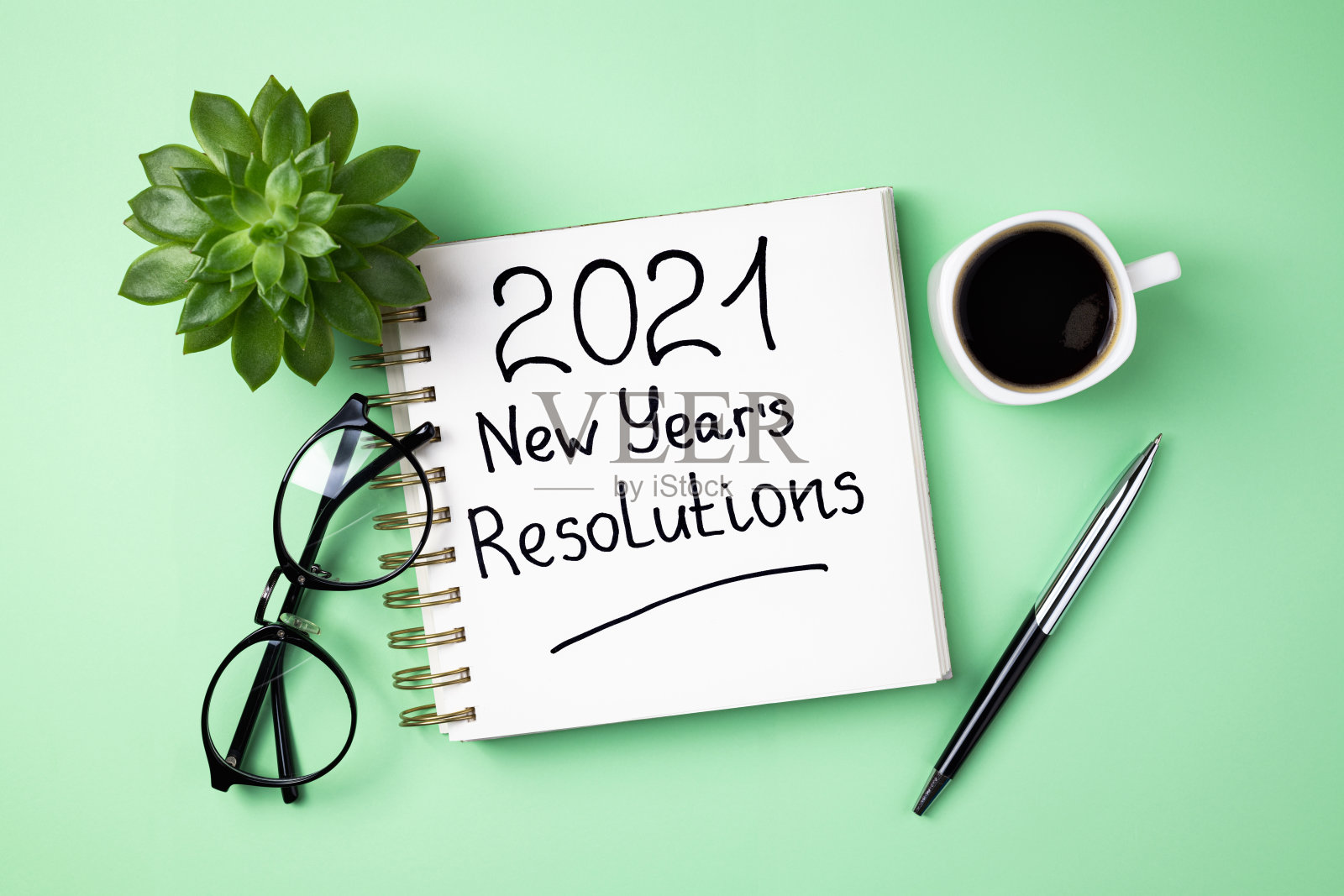 办公桌上的2021年新年目标。打开笔记本,咖啡杯,眼镜,绿色背景植物的2021年目标。目标,决议,计划,策略,想法概念。新2021年照片摄影图片