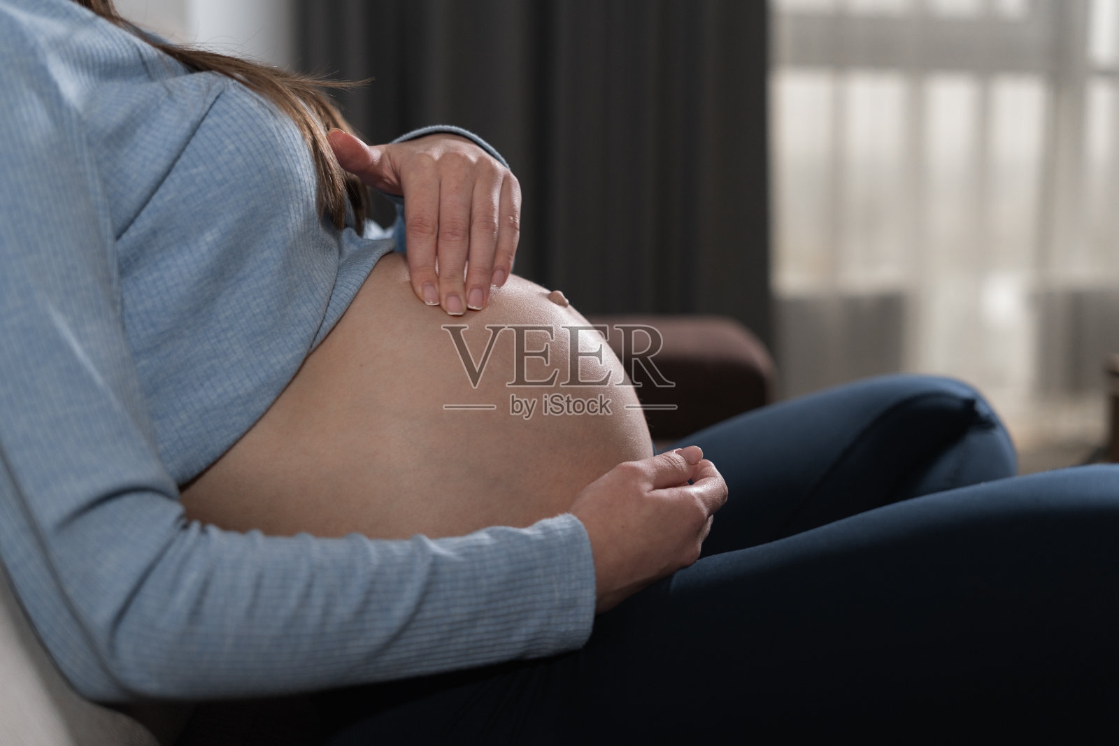 特写腹部的孕妇抚摩它与她的手。照片摄影图片