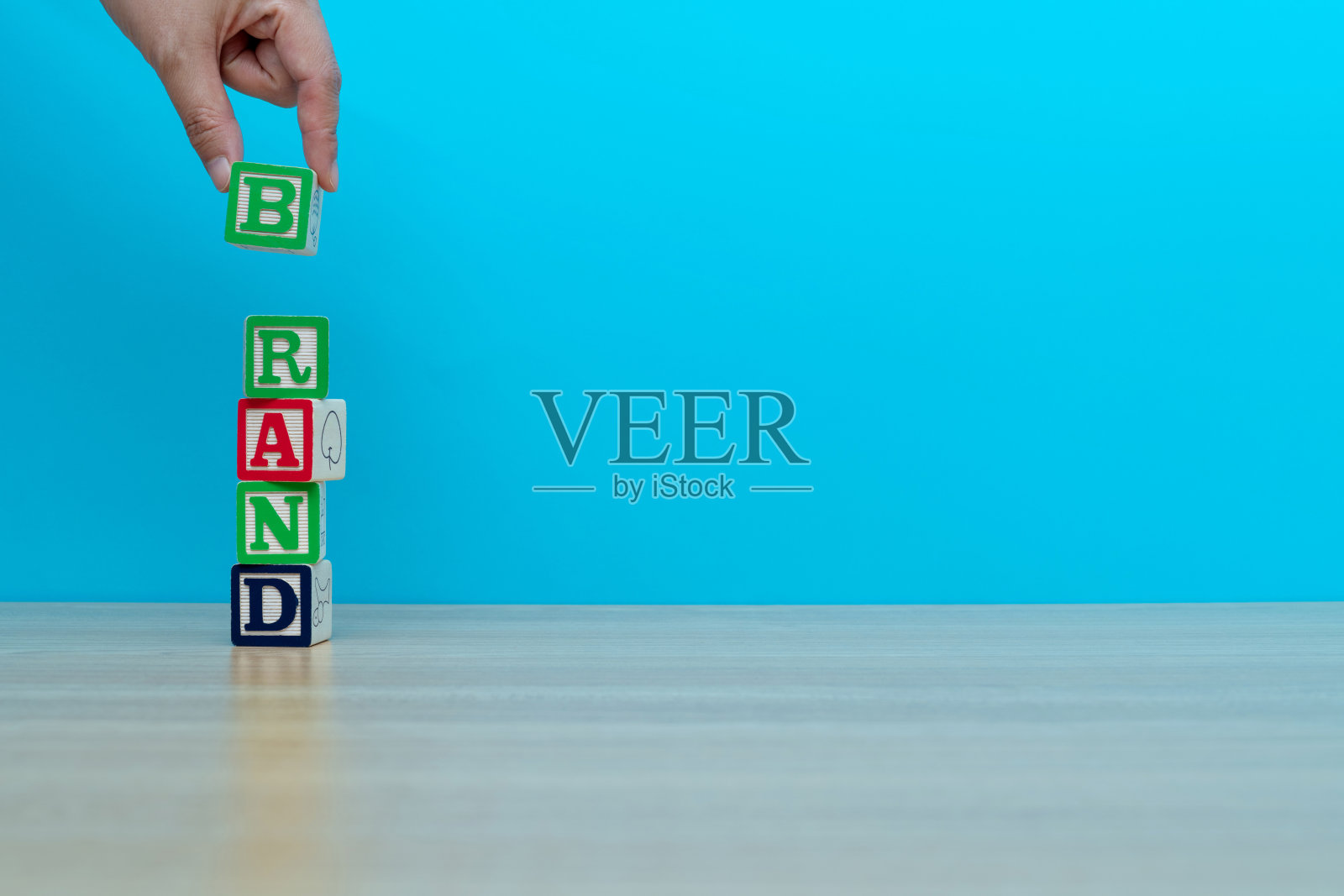 人的手拼字品牌与玩具积木照片摄影图片