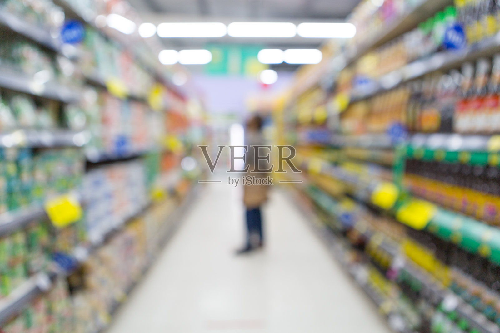 模糊的女人正在超市的货架上购物照片摄影图片
