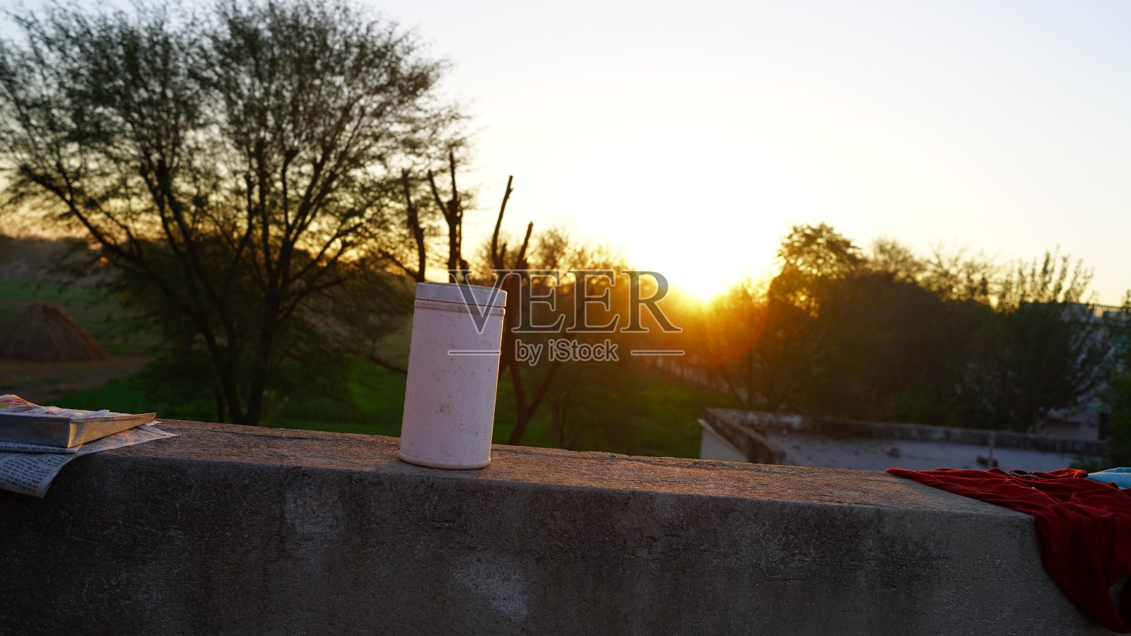 近距离观看白色苏打水可以查看持有胶结墙与日落背景自然。软饮料可以模拟照片摄影图片