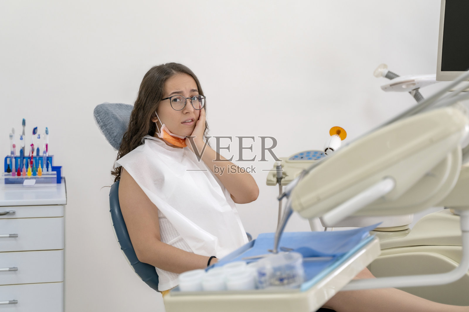 一名少女在牙科诊所接受牙科检查时牙痛照片摄影图片