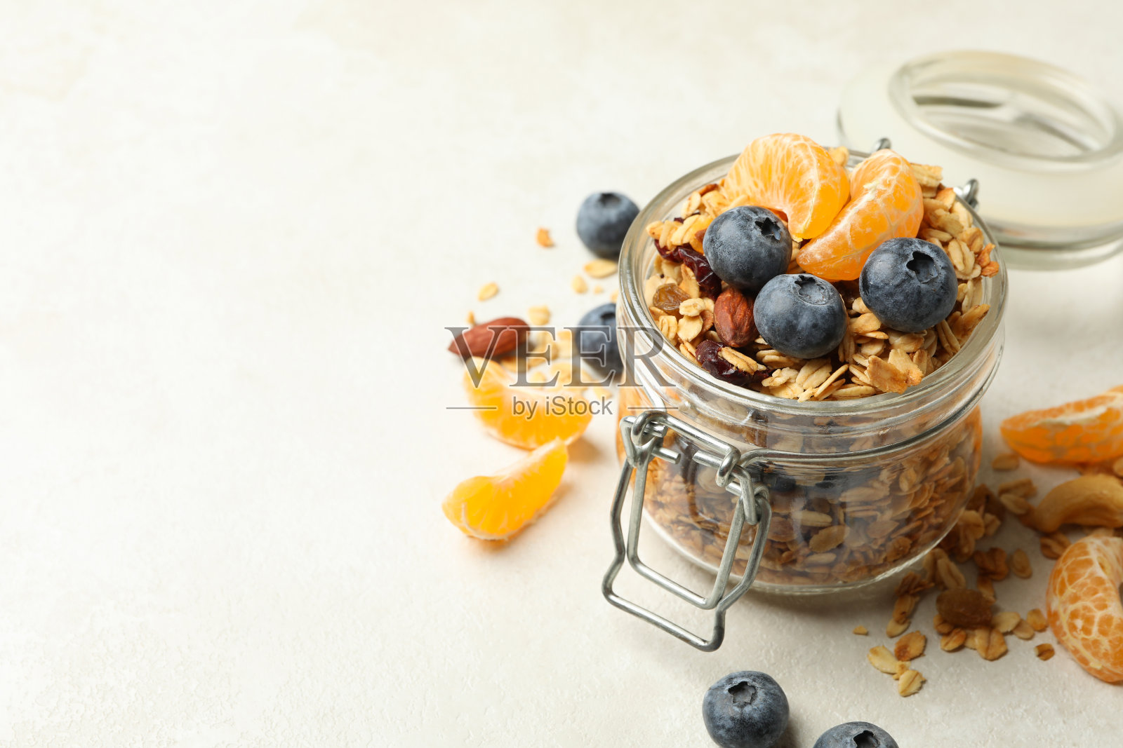 白色背景上有美味的格兰诺拉麦片的玻璃罐照片摄影图片