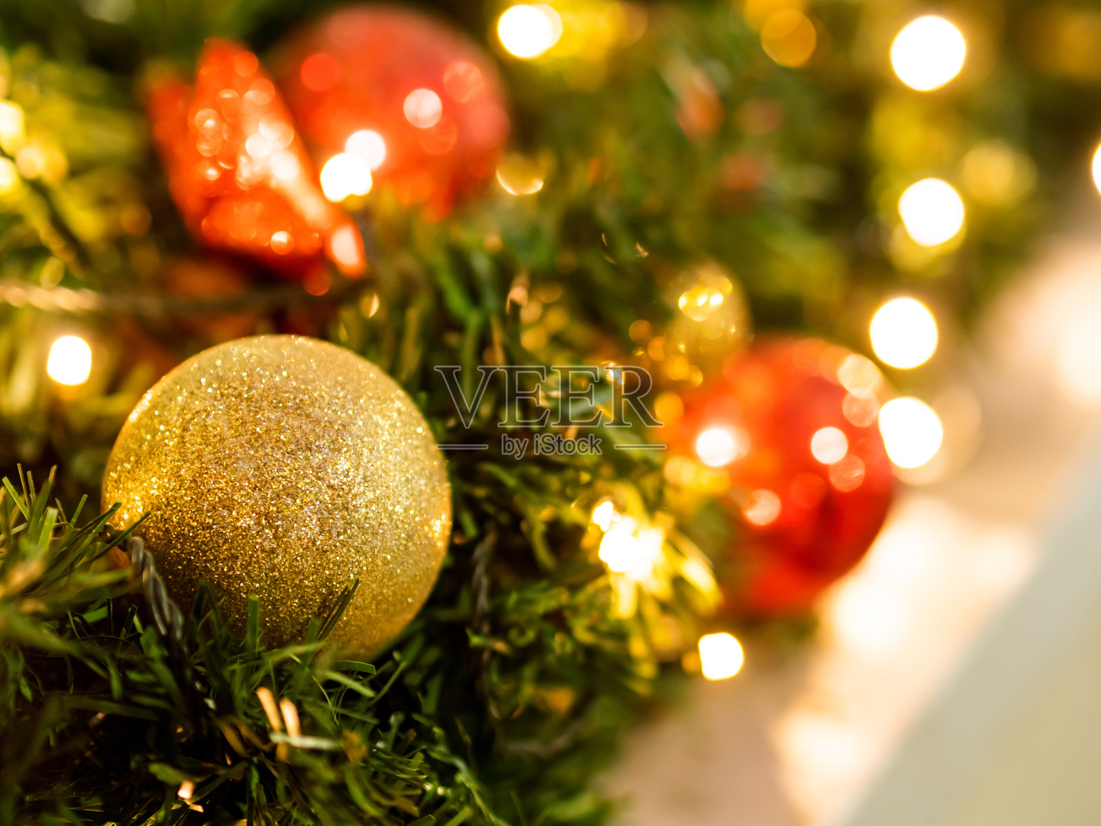 圣诞树上五颜六色的装饰品。红色和金色的人物庆祝新年。节日的背景。照片摄影图片