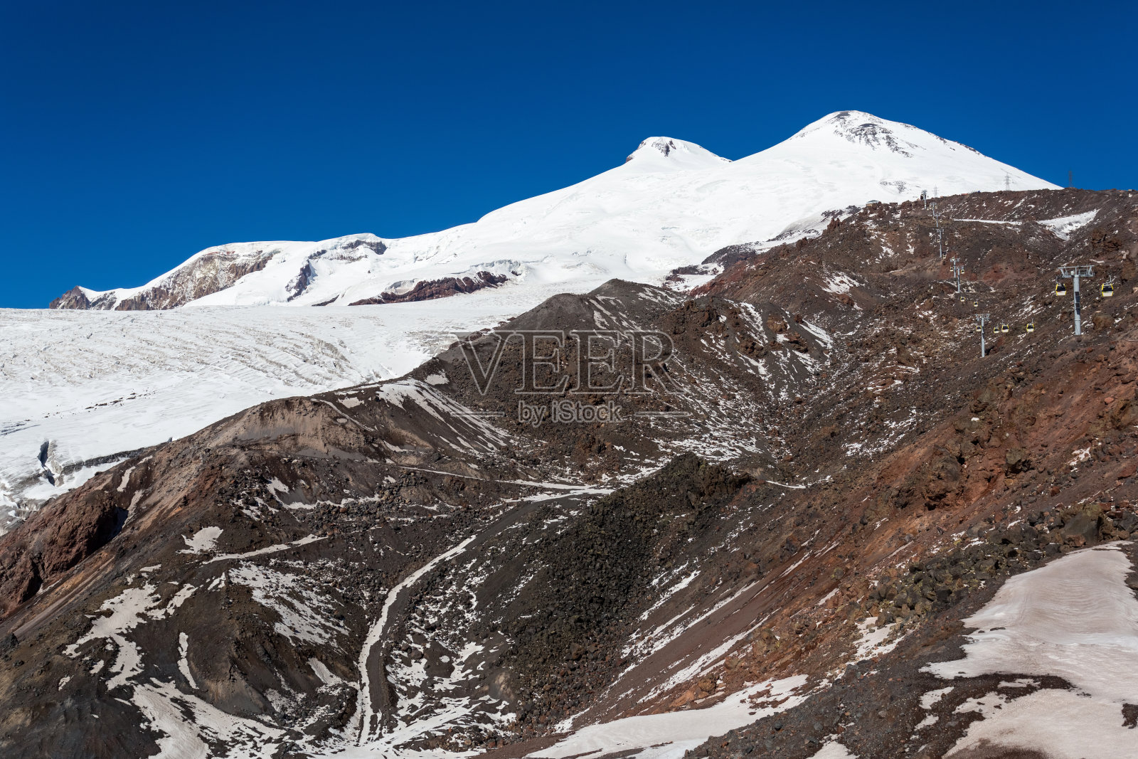 岩石,白色的斜坡和高加索的厄尔布鲁斯的山顶照片摄影图片
