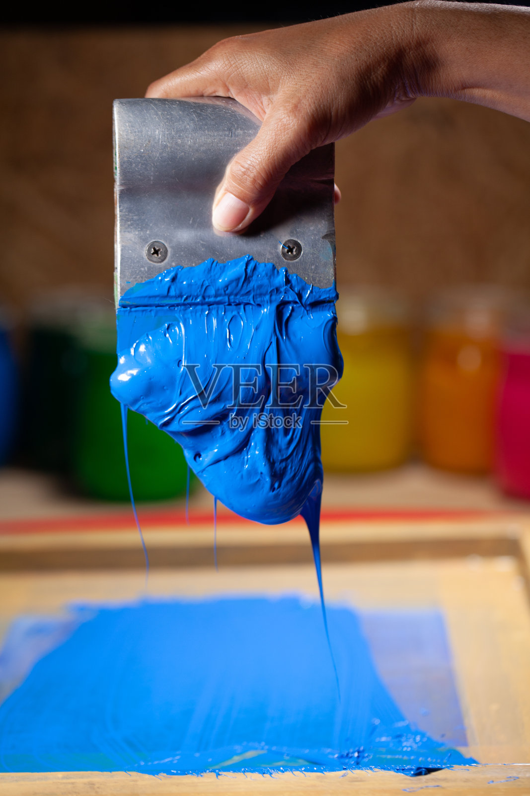 蓝色从手上滴落的丝网印刷照片摄影图片