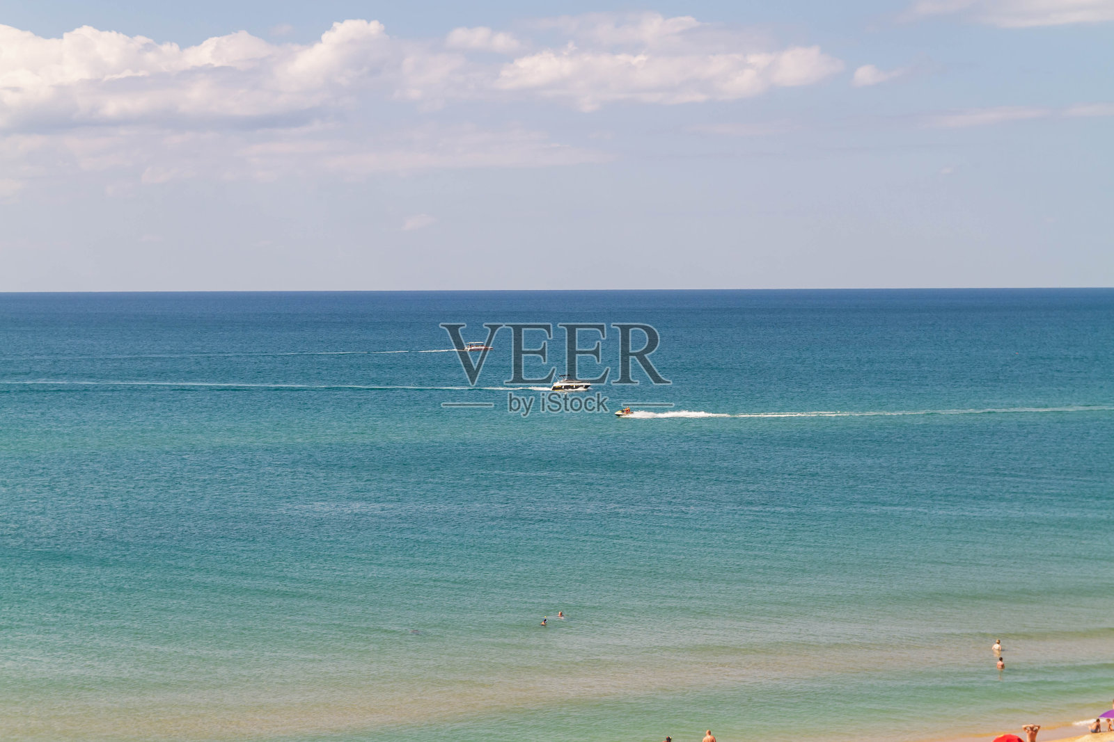 夏天,白色的小船漂浮在海浪上照片摄影图片