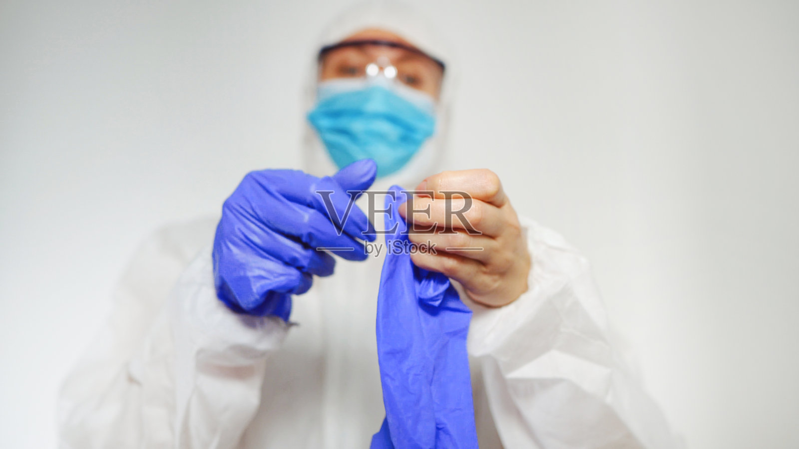 医护人员穿着防护服戴上手套。照片摄影图片