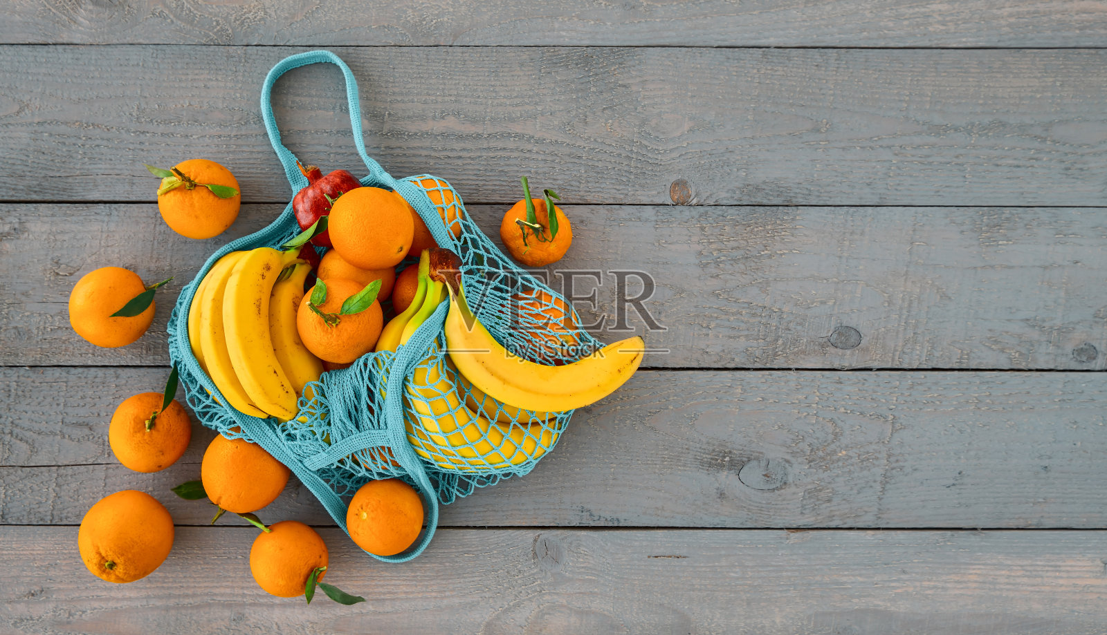 购物时不用塑料袋。“零浪费”的概念。环保的天然可重复使用的袋子与有机水果,橙子和香蕉。顶视图与复制空间,木材背景照片摄影图片