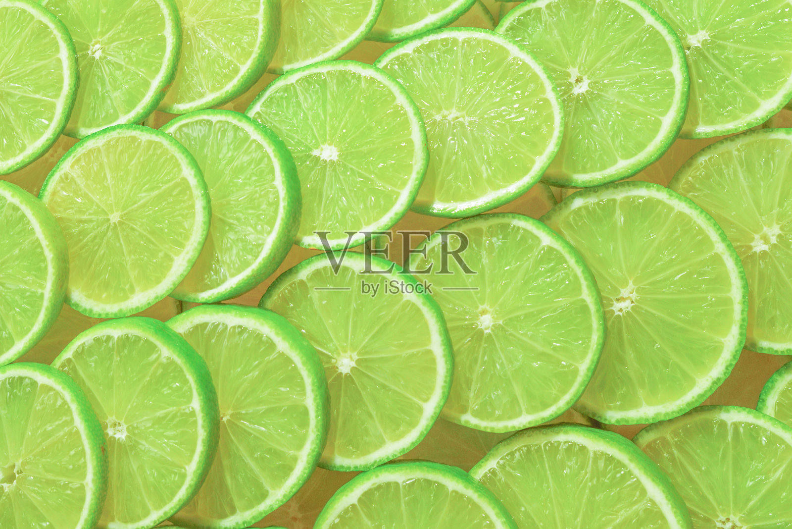 新鲜的酸橙片作为背景。照片摄影图片