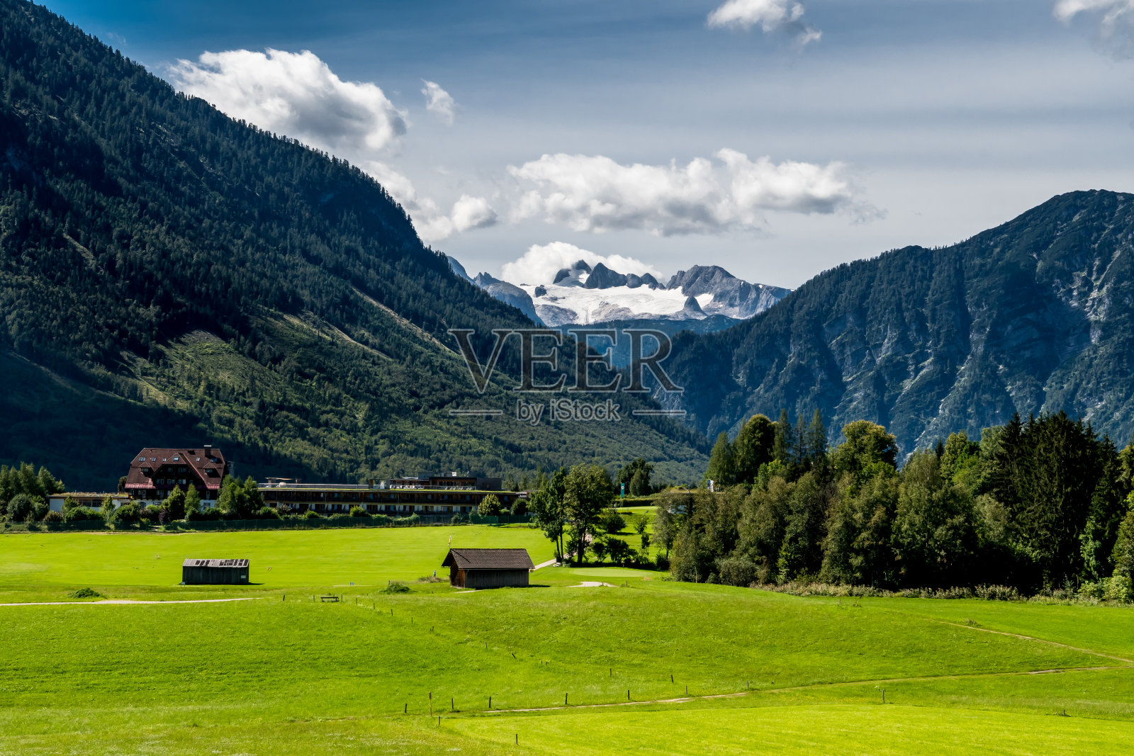 奥地利阿尔卑斯山达赫斯坦山前的乡村景观和房屋照片摄影图片