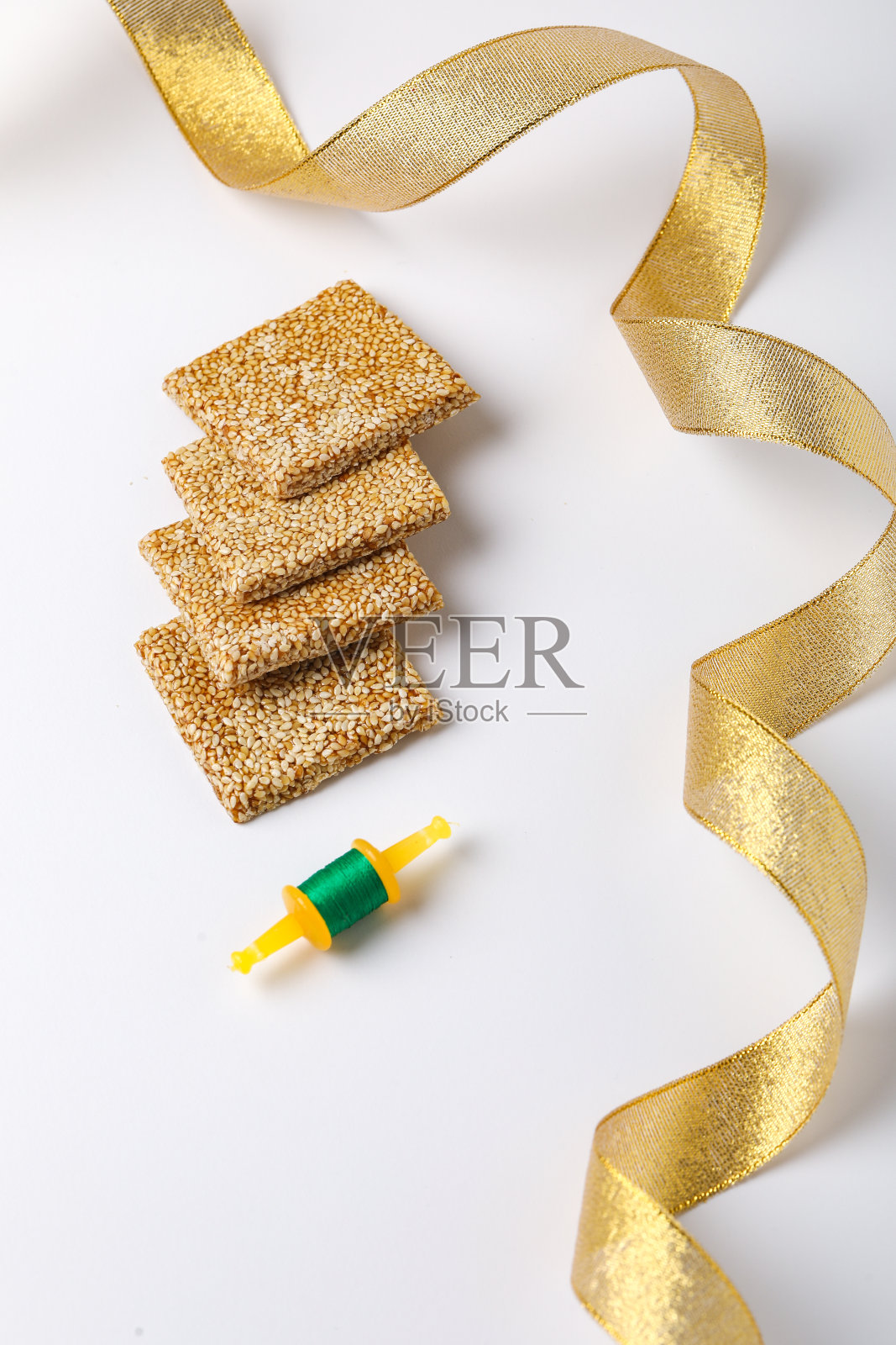 用芝麻和彩色纸风筝制作的印度甜风筝,在白色的背景上庆祝印度的马卡尔桑克拉提节照片摄影图片