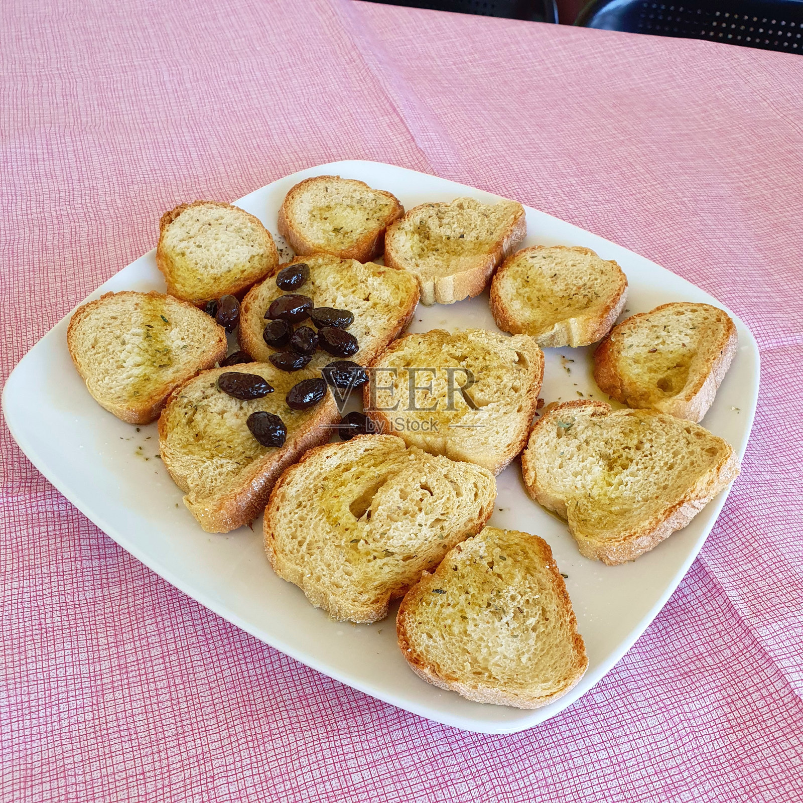 面包加橄榄油和橄榄。品尝葡萄酒的小吃。照片摄影图片