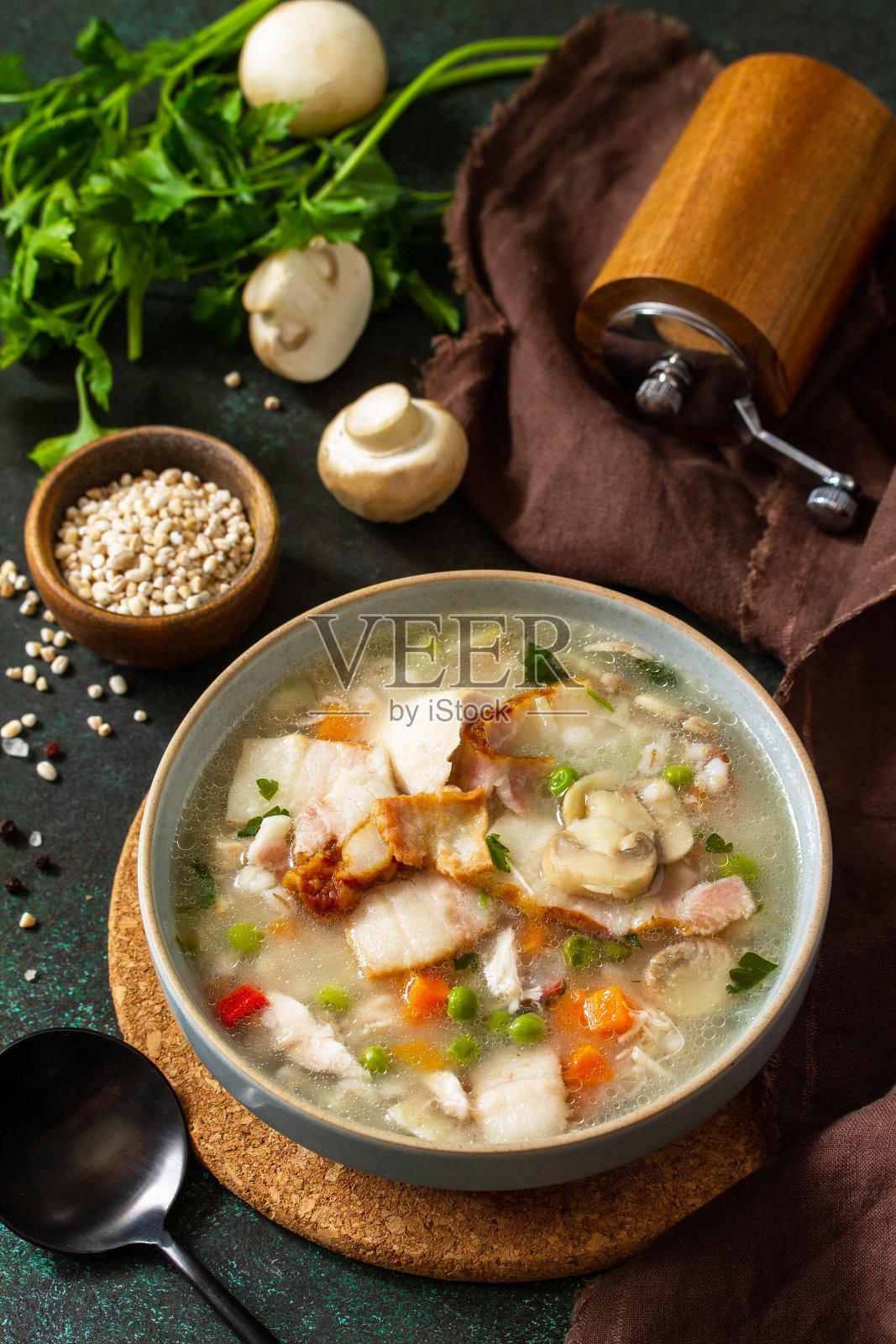 健康饮食。在黑色的石头背景上,自制的丰盛的麦片、培根和蘑菇汤。照片摄影图片
