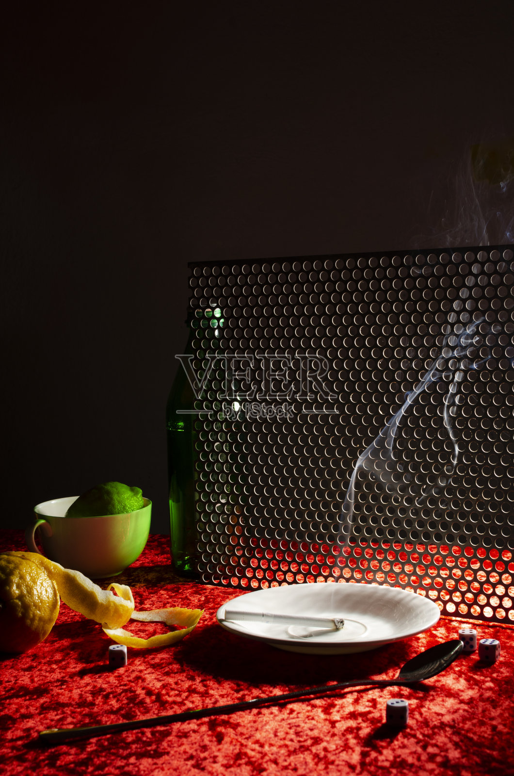 垂直的图像。白色的烟灰缸,柠檬,红色桌布上的绿色瓶子。酒吧里的黑夜照片摄影图片