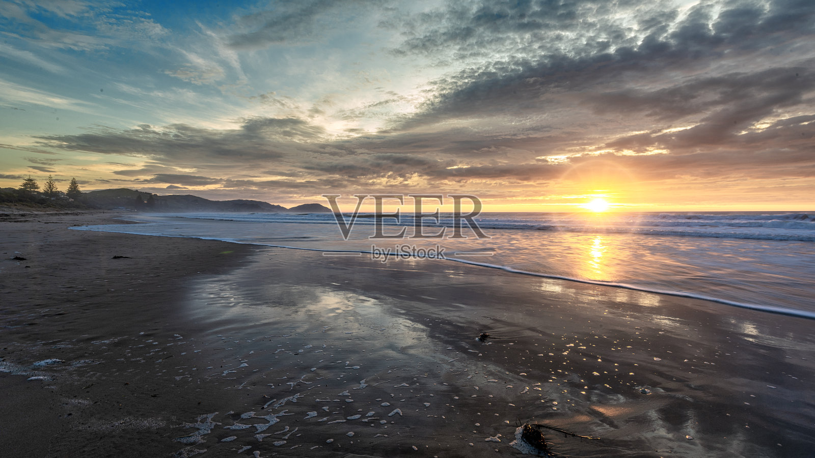 金色的日出横跨海洋在海滩上照片摄影图片