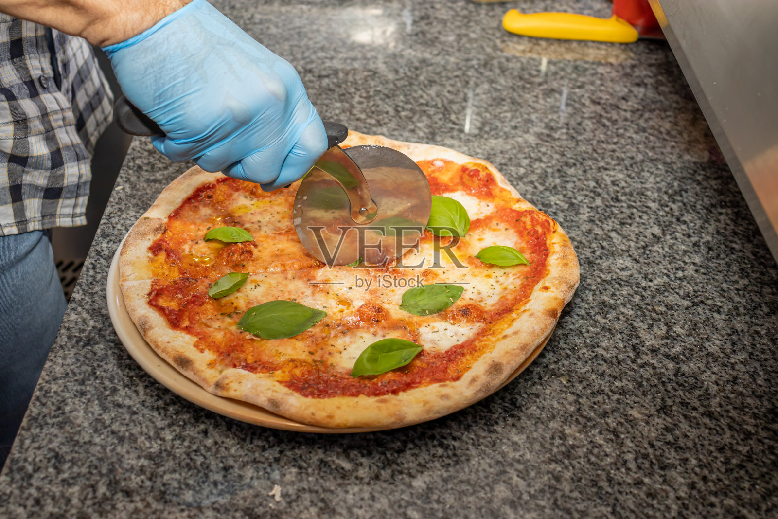 一名男子在当地一家披萨餐厅切玛格丽塔披萨照片摄影图片