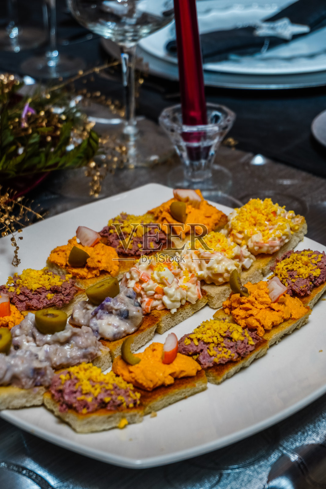 各种配橄榄,蛋黄酱,鸡蛋和肉酱的开胃小菜放在装饰好的桌子上照片摄影图片