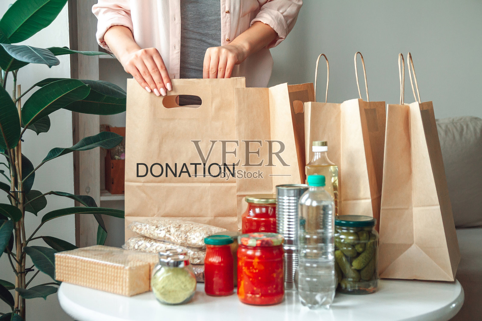 一名妇女将捐赠的食物装在纸袋里照片摄影图片