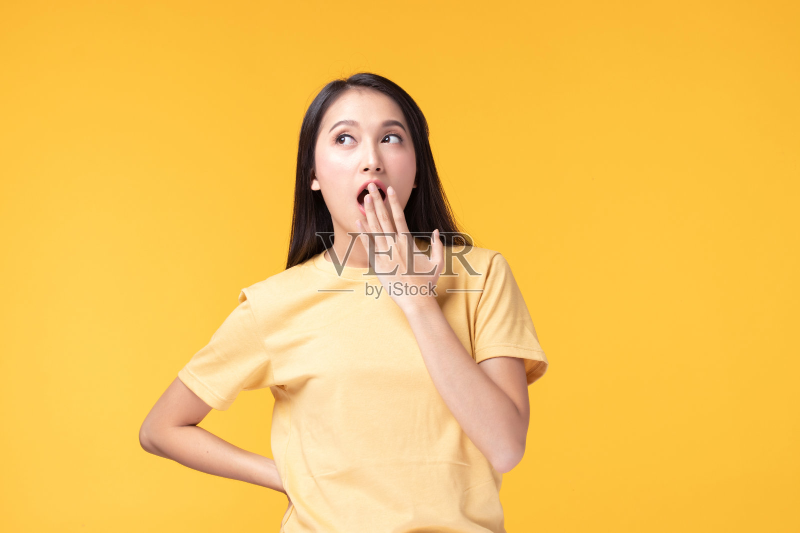 感觉兴奋,震惊,惊讶和快乐的形象。站在黄色背景上的年轻亚洲女子。女性面部表情和情绪肢体语言概念。照片摄影图片