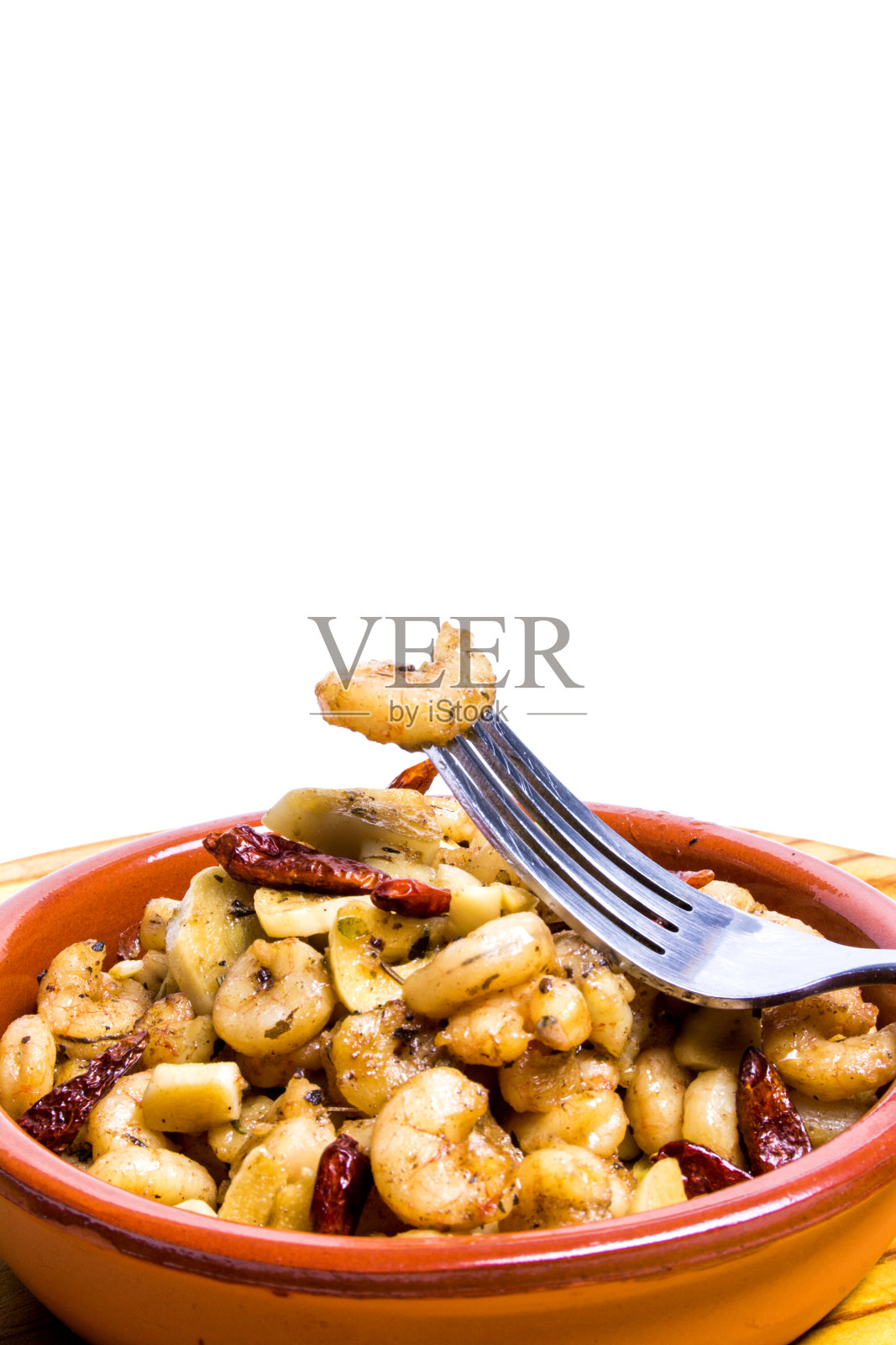 用瓷碗盛着蒜和辣椒的大虾,放在木托盘上照片摄影图片