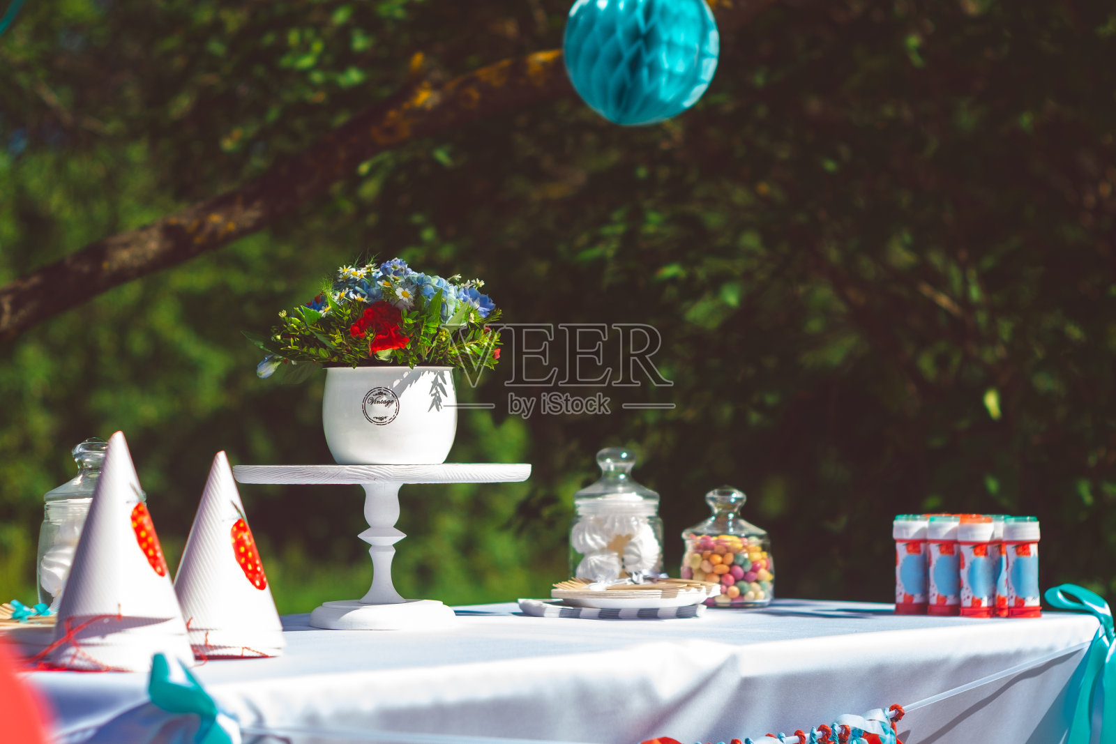 为节日做准备,用彩球和彩带装饰花园。派对在花园户外背景使用。照片摄影图片