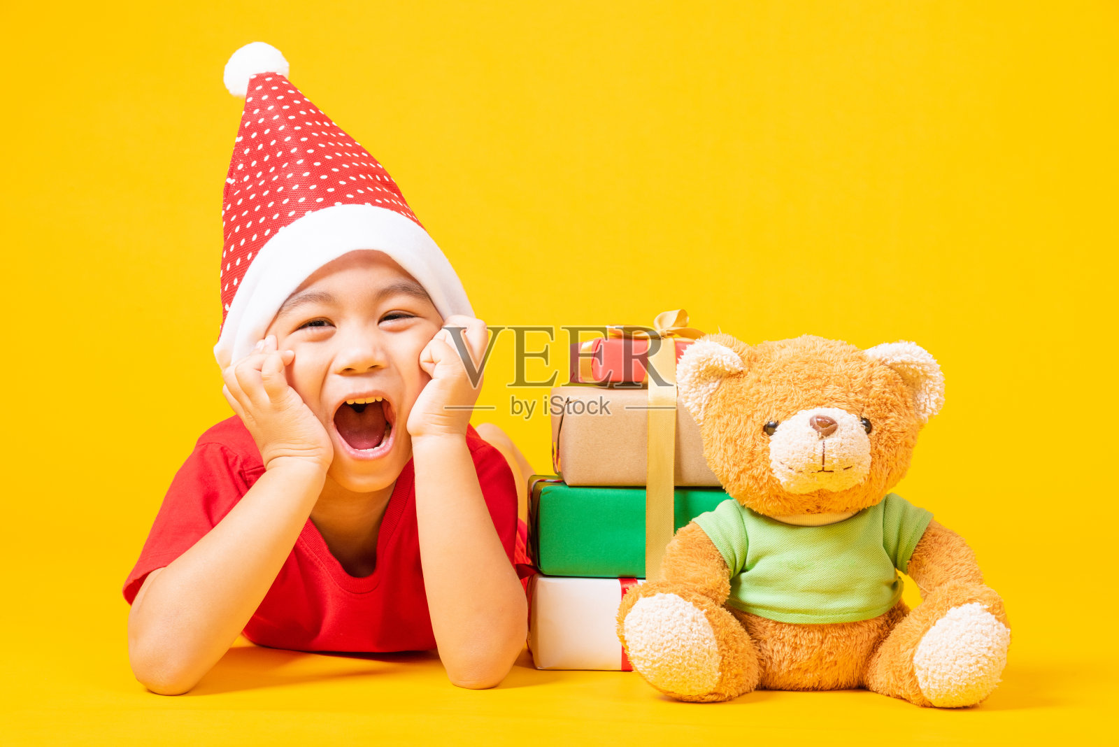 小朋友戴着圣诞老人的红色帽子,是圣诞佳节的概念照片摄影图片