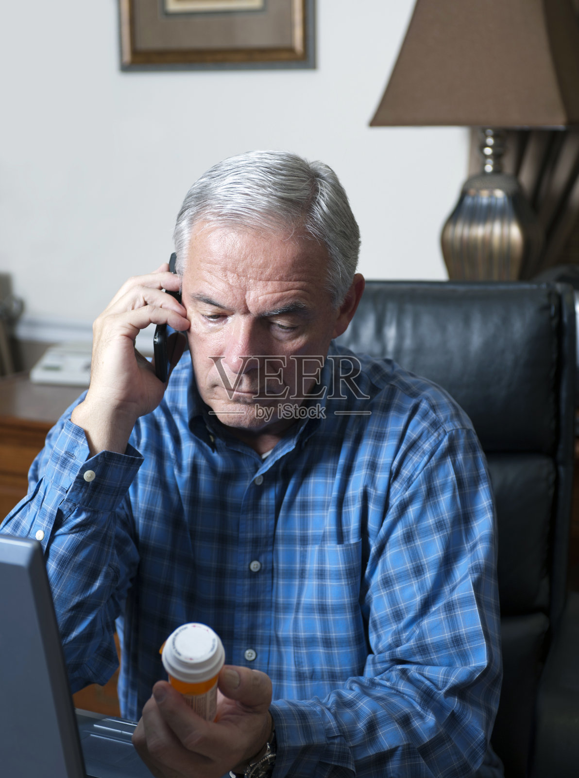 老在电话里拿着药瓶照片摄影图片