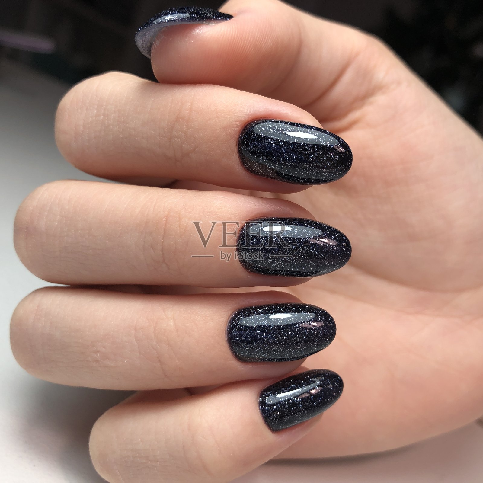 时尚时尚的黑色女性美甲。一个涂着黑色指甲的女人的手照片摄影图片