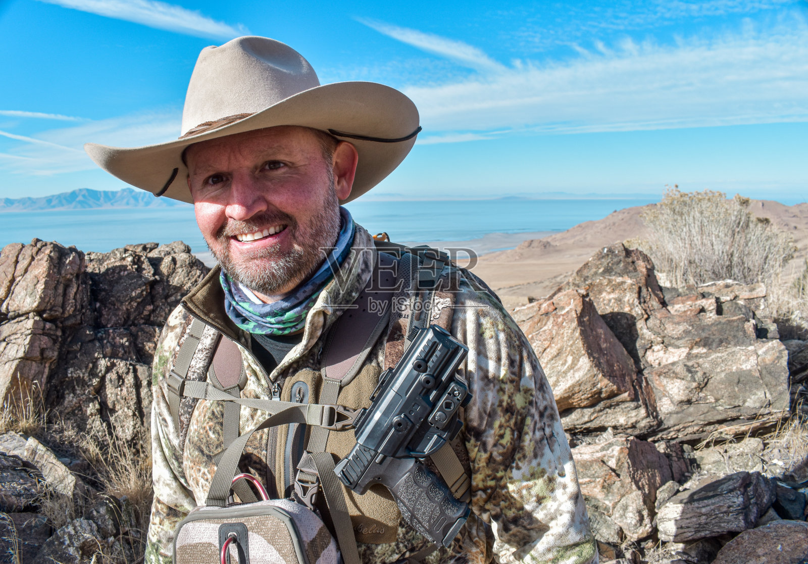 迷彩猎人与牛仔帽迷彩手枪双筒望远镜照片摄影图片