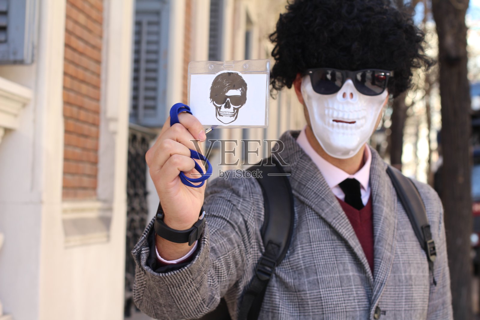 带着骷髅脸出示身份证的商人照片摄影图片