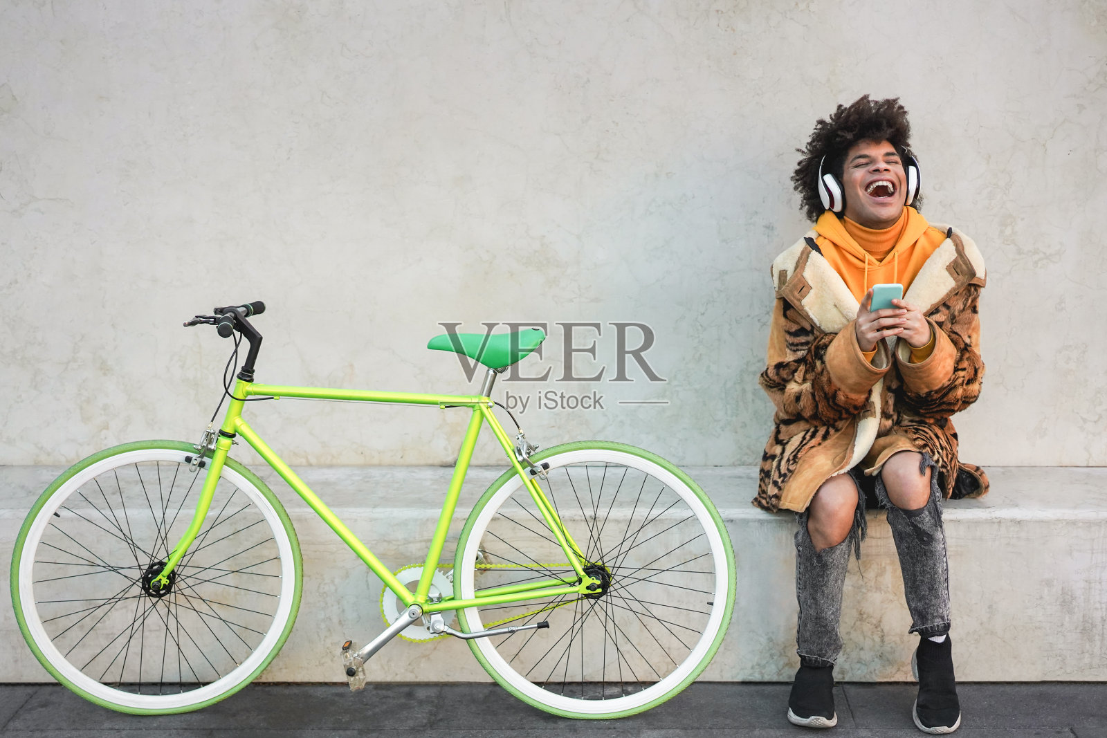 开朗的黑人少年在手机上听音乐播放列表-专注于脸照片摄影图片