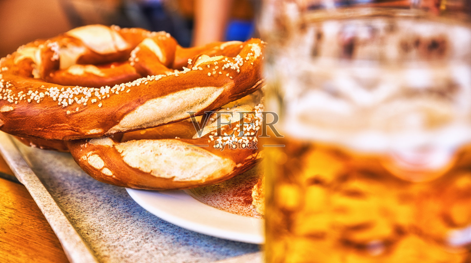 椒盐卷饼(Brezeln)、海盐和一杯啤酒,放在质朴的木桌上照片摄影图片