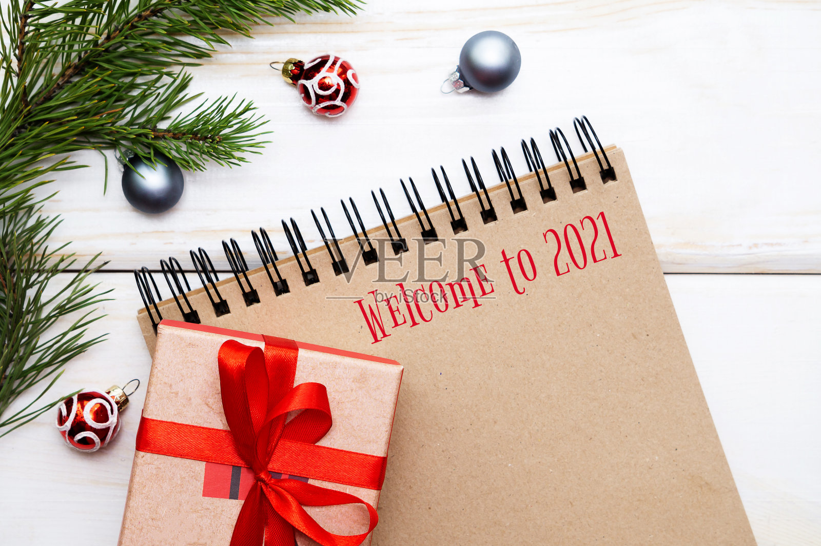 欢迎来到2021年。一张螺旋形的空笔记本的照片,棕色的床单,新年礼物,圣诞装饰品。选择性聚焦,平铺照片摄影图片