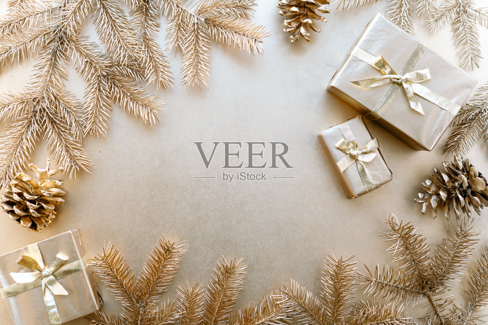 金色圣诞或新年的背景,金色圣诞礼物的简单构图,金色冷杉的树枝和金色松果,平铺,空白的问候文字。照片摄影图片