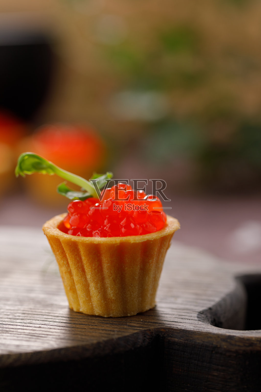 开胃的馅饼与红鱼子酱和微绿色装饰。节日的概念。特写镜头。副本的空间。照片摄影图片