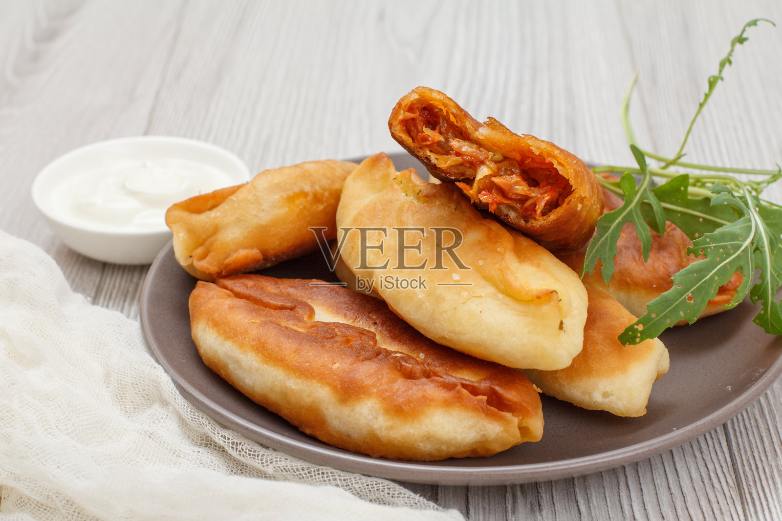 在木板上盛有油炸馅饼的盘子。照片摄影图片