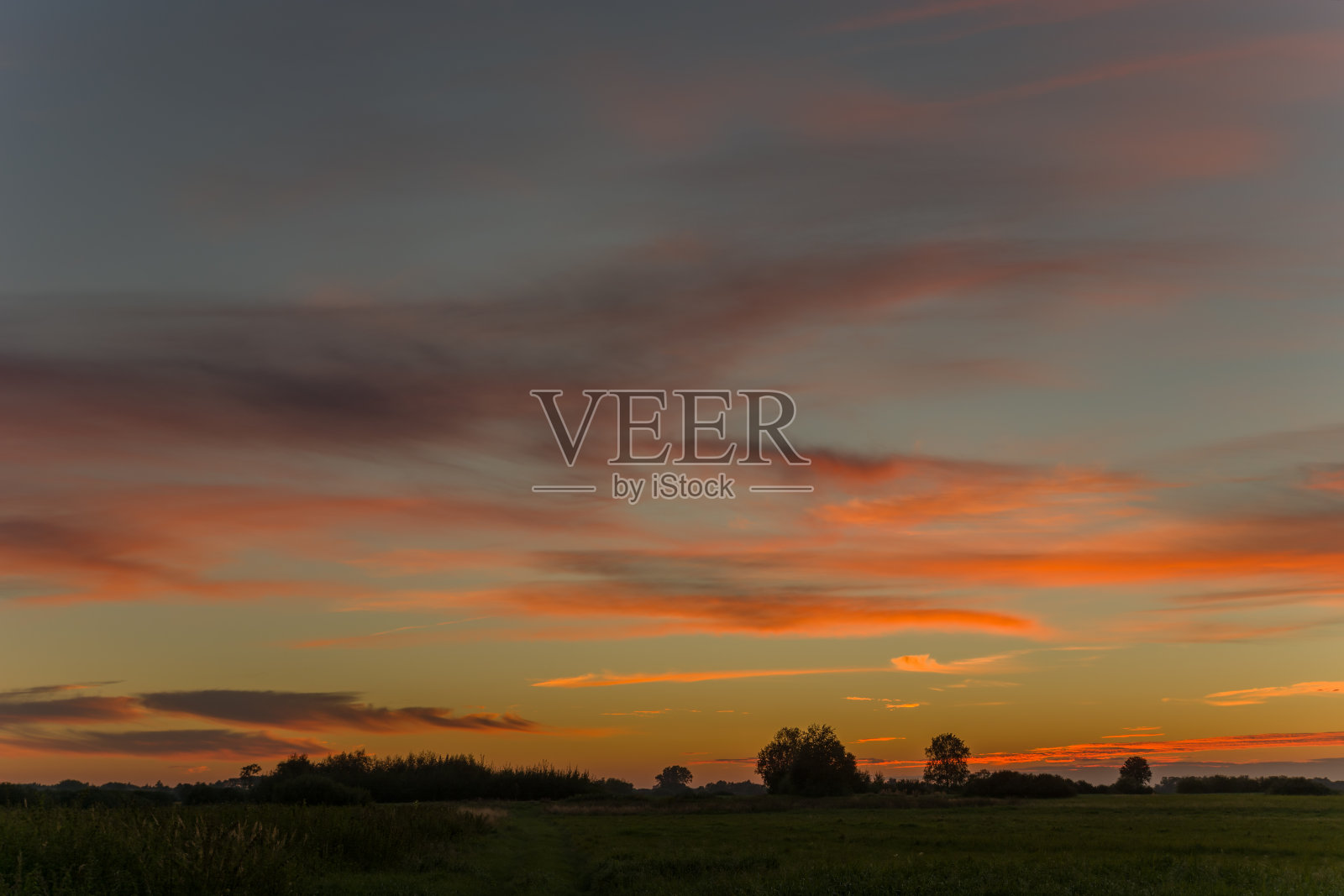 日落后的草地和天空中的彩云照片摄影图片